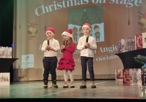 Szymon, Zuzia i Marcel stoją na scenie i śpiewają piosenkę "Twinkle twinkle christmas star".
