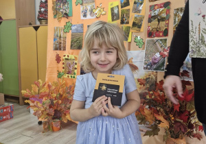 Emilia z grupy Pszczółek odbiera nagrodę za udział w konkursie.