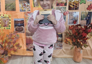 Klara z grupy Biedronek pozuje do zdjęcia na tle dekoracji.