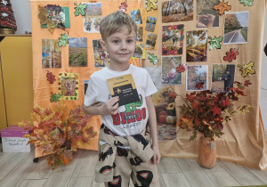 Oluś z grupy Biedronek trzyma w dłoniach nagrodę otrzymaną za udział w konkursie.