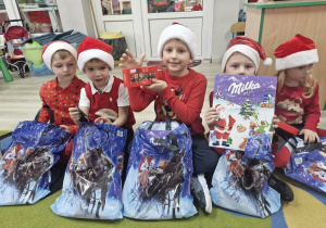 Wojtuś, Ignaś, Franek, Lucjan i Ala rozpakowują prezenty od Mikołaja.