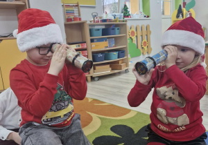 Tymek i Ala spoglądają przez kalejdoskopy pozostawione dla dzieci przez Mikołaja.
