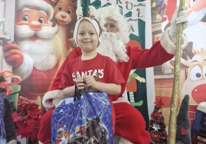 Karol pozuje do zdjęcia ze Świętym Mikołajem.