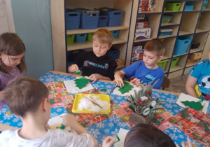 Grupka dzieci podczas malowania choinek.