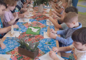 "Słoneczka" podczas pracy siedzą przy udekorowanym wspólnym stole.