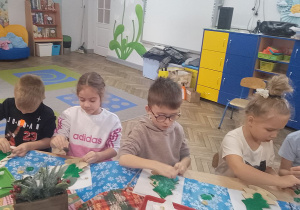 Grupka dzieci podczas malowania choinek.
