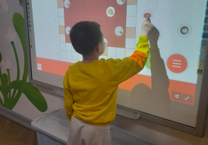 Antek przesuwa na tablicy multimedialnej obrazek z potrawą wigilijną.