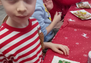 Adaś prezentuje swoje udekorowane pierniki.