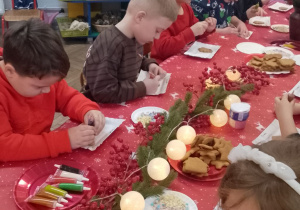 Grupka dzieci ozdabia świąteczne pierniki.