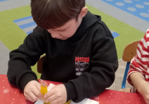 Mateusz ozdabia swoje pierniki lukrem.