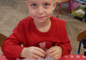 Wiktor ozdabia swój pierniczek lukrem.