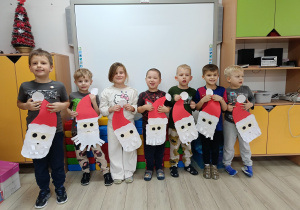 Dzieci pozują z wykonanymi przez siebie pracami.