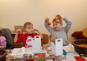 Hubert i Bruno podnoszą do góry swoje bombki.