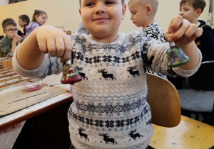 Julek prezentuje dwie bombki, które ozdobił według swojego pomysłu.