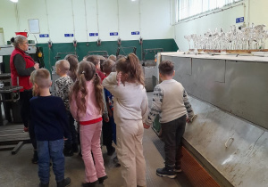 Dzieci podczas zwiedzania fabryki stoją przed Panią w dziale o nazwie srebrzalnia.