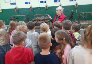 Dzieci w dziale srebrzalnia oglądają maszynę o nazwie wytrzęsarka.