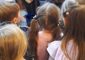 W dziale malarnia dzieci obserwują jak Pani wkłada bombki do tunelu.