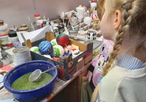 Dwie dziewczynki w dziale dekoratornia oglądają ozdobione bombki.