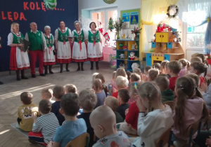 Dzieci słuchają kolęd śpiewanych przez Zespół "Leszczynianki".