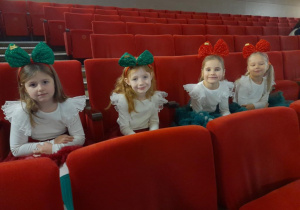 Dziewczynki siedzą obok siebie na widowni.