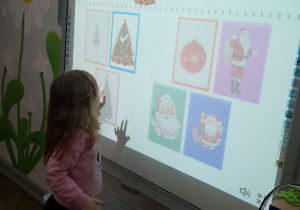 Emma dopasowuje obrazki do pary na tablicy multimedialnej.