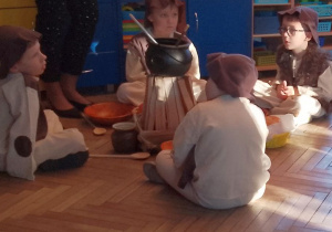 Czterech chłopców w roli Pasterzy siedzi wokół ogniska.