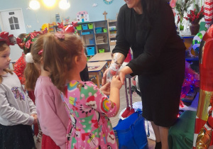 Dzieci dziękują mamie Nadii za piękne czytanie i wręczają upominek.