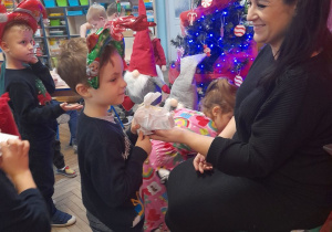 Mama Nadii wręcza dzieciom mikołajkowe niespodzianki.