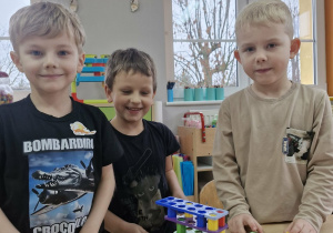 Olek, Franek i Lucjan układają wieżę z klocków Numicon.