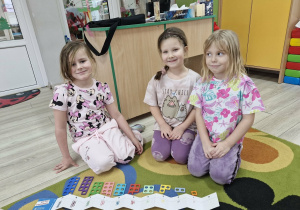 Weronika, Maja i Nadia pokazują ułożone według podanego wzoru klocki Numicon.