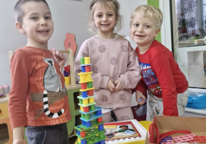 Wojtek, Lila i Karol prezentują wieżę ułożoną z klocków Numicon.