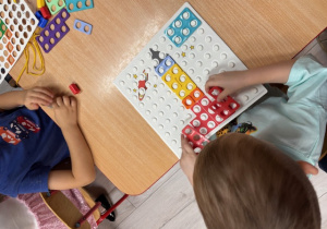 Olek układa rakietę z klocków numicon.