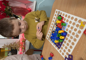 Michałek buduje samochód z klocków numicon.