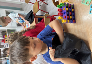 Leon buduje wieżę z klocków numicon.