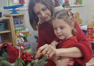 Ola ze swoją mamą komponują świąteczny stroik.