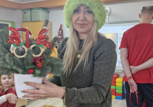 Mama Lucjana w świątecznej czapce prezentuje gotowy stroik.