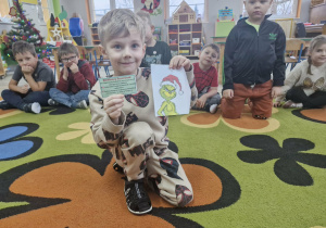 Oluś wyjmuje z koperty kartkę z poleceniem od Grincha.