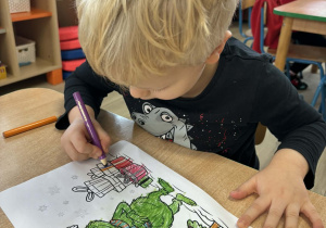 Karolek w trakcie kolorowania obrazka z wizerunkiem Grincha.