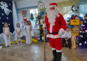 Mikołaj stoi na środku sali w grupie "Słoneczka".