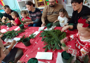Uczestnicy warsztatów docinają gałązki jodły.