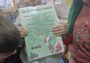 Antoś trzyma w dłoniach list od Grincha wyjęty z koperty.