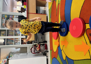 Olaf przechodzi po dyskach sensorycznych. Obok nich leżą strzałki, które wskazują drogę w którym kierunki iść.