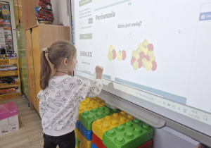 Oliwia rozwiązuje quiz matematyczny na tablicy multimedialnej.