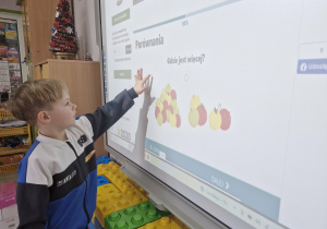 Wojtuś w trakcie rozwiązywania zadania na tablicy multimedialnej.