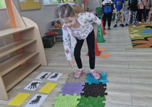 Ola z grupy "Biedronek" porusza się po torze przeszkód zgodnie z zakodowaną instrukcją obrazkową.