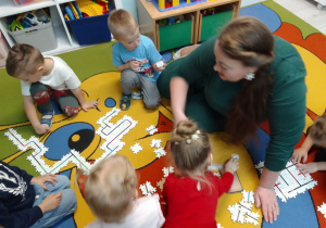 Pani z biblioteki ogląda ułożone przez dzieci trasy dla Ozobotów.