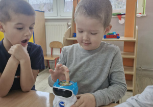 Julek programuje robota. Obok Staś przygląda się działaniom kolegi z zaciekawieniem.