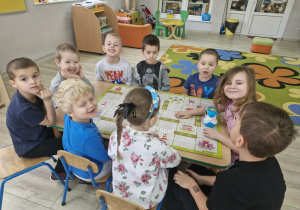 Dzieci siedzą przy stoliku w trakcie zabaw w programowanie z robotami.