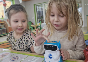 Nadia koduje robota, obok przygląda się Maja.