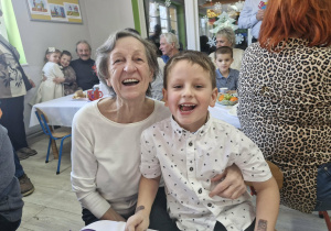 Franuś i jego babcia wesoło uśmiechają się do zdjęcia.